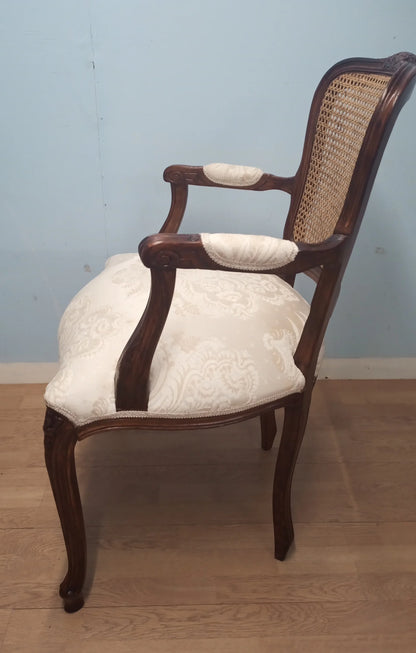Elegante poltrona a pozzetto in noce vintage restaurata con schienale in canna e rivestimento crema