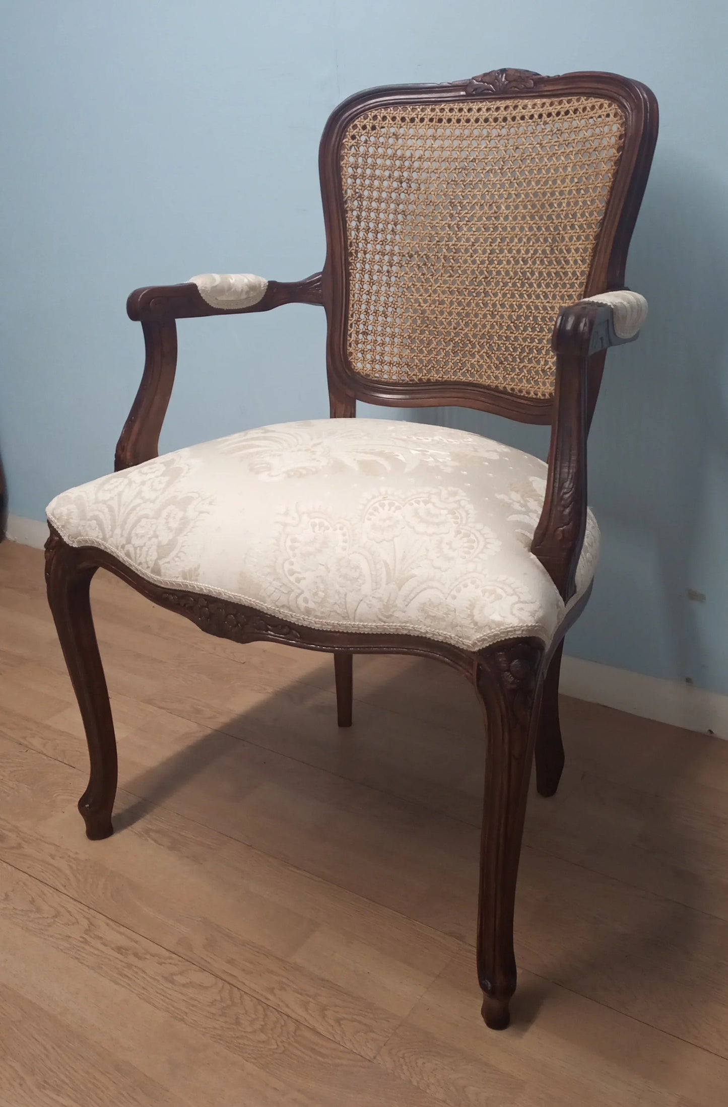 Elegante poltrona a pozzetto in noce vintage restaurata con schienale in paglia di vienna e seduta crema imbottita