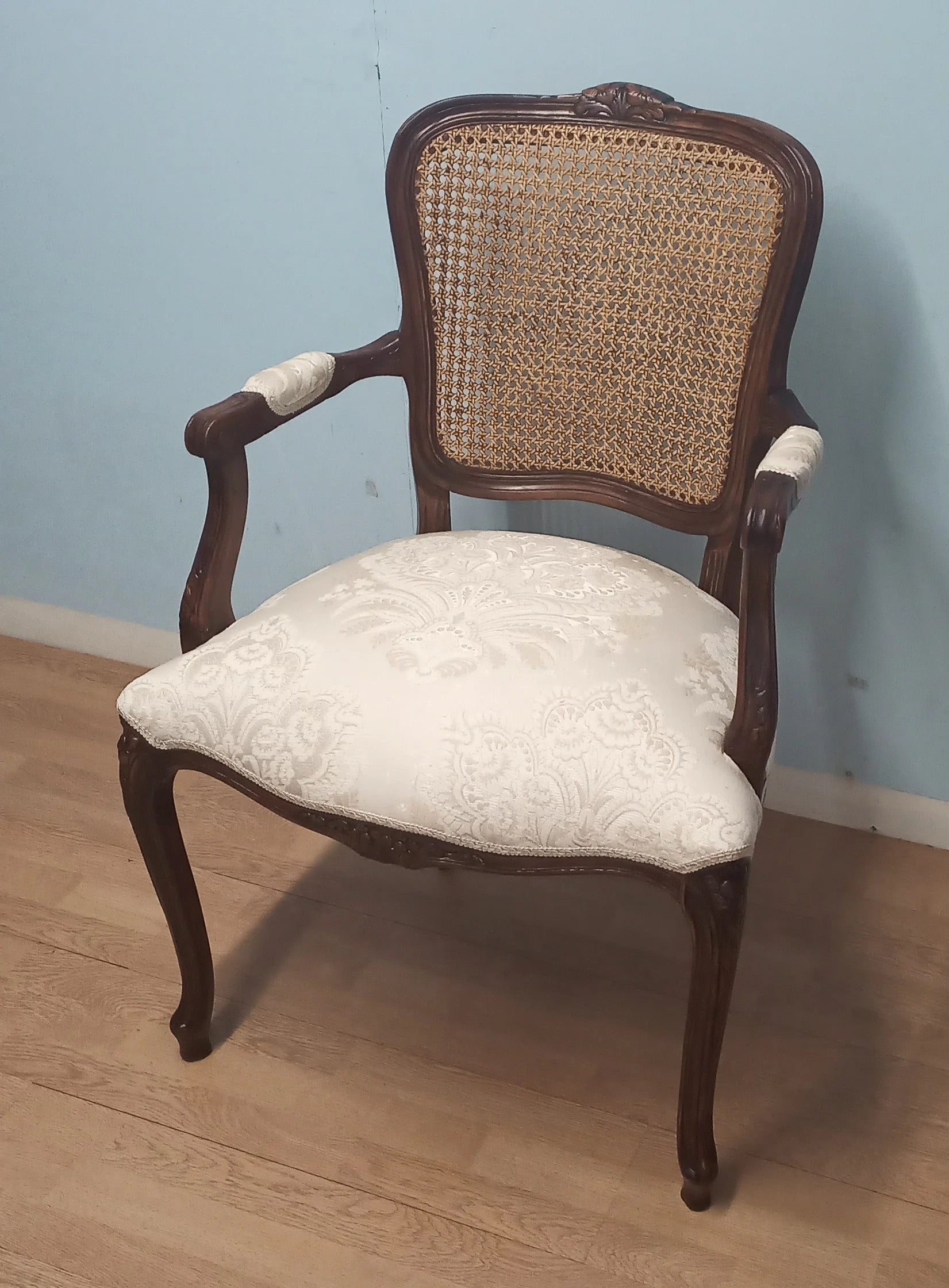 Poltrona a pozzetto vintage restaurata in noce con schienale impagliato e seduta imbottita color crema